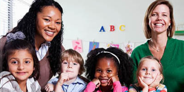 Young children and teachers smiling in the classroom