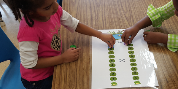 Two girls playing with lily pad math game 