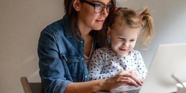 mother and daughter typing on a laptop