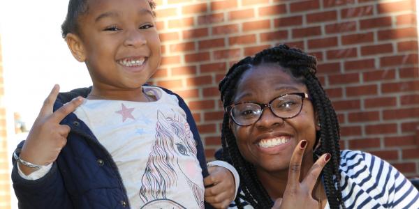 a teacher and child smiling at the camera