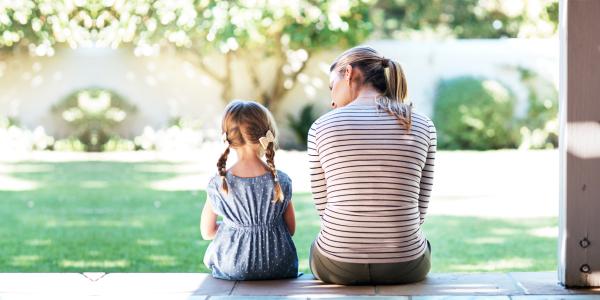 a child and adult sitting on the porch having a discussion