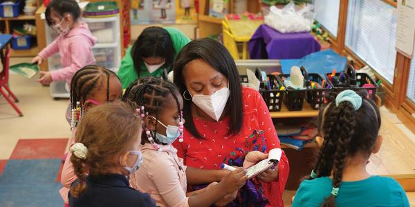 Feature Teacher Curti Dunmore reading with her students,