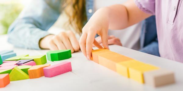 close up on a childs hands playing with blocks
