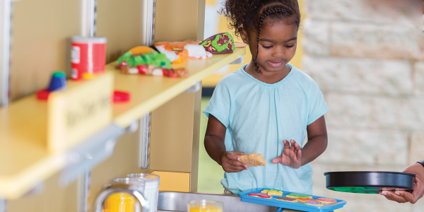 a young child playing with a pretend kitchen toyset