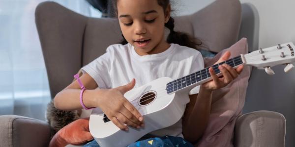 child laying ukulele