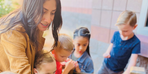 A group of children with a teacher looking at a garden.