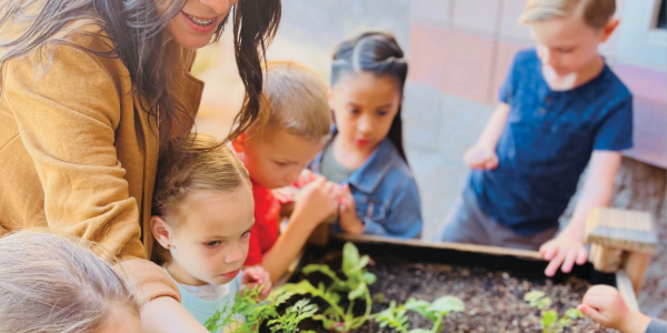 a teacher showing students a garden