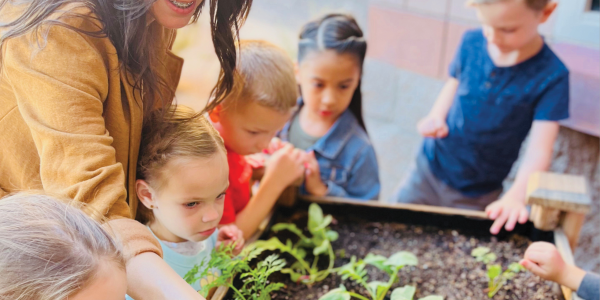 a teacher showing students a garden