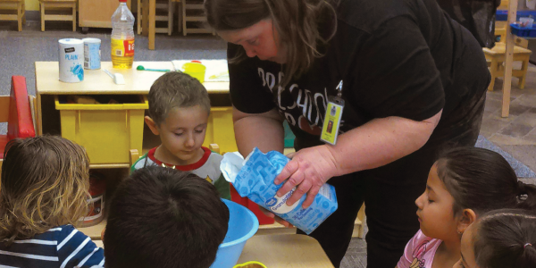 a teacher pouring sugar into a bowl