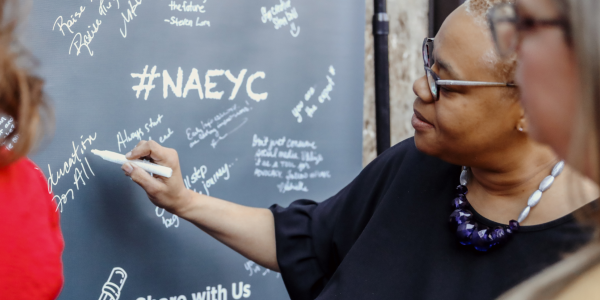 NAEYC member writing on a chalk board