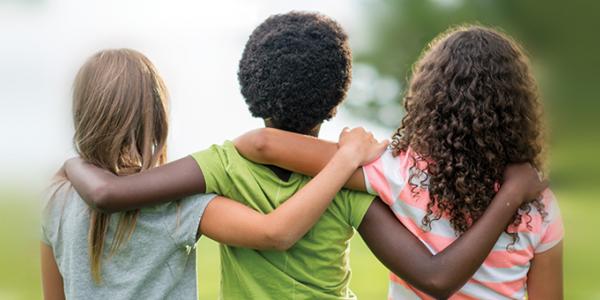 Three children hugging each other