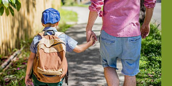 Father and son holding hands outside 