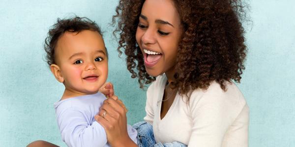 Mother laughing and holding son.