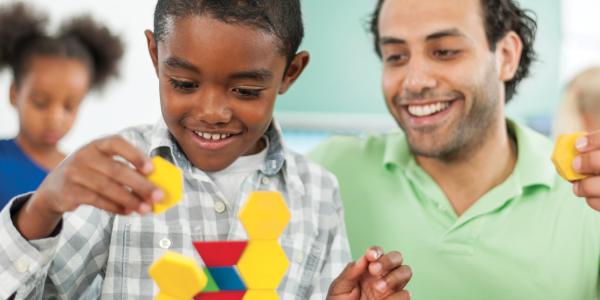 Teacher observing a child build a toy structure