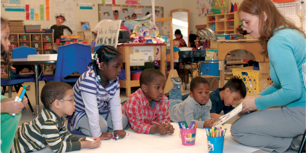 Teacher helping preschool class