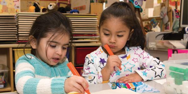 Two students drawing in a classroom
