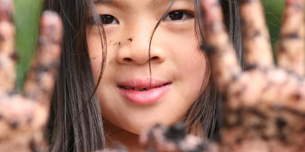 Girl with mud on hands