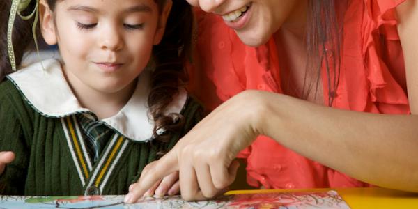 Child and teacher reading a book