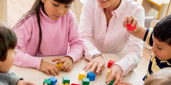 Children and teacher playing with blocks