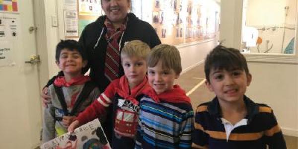 Teacher and students smiling with artwork