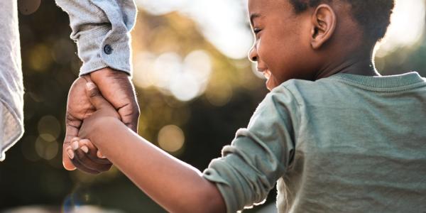 a child holding hands with an adult