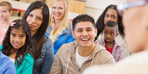 Families and children sitting in a room with the educator answering questions