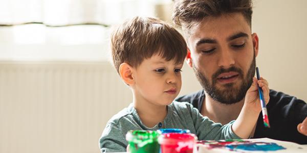 Dad helping child to paint