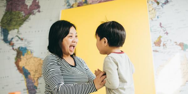 Mom and son smiling at each other with map in background