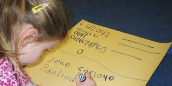 Child writing on poster 