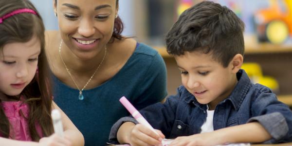 Teacher helping students to write