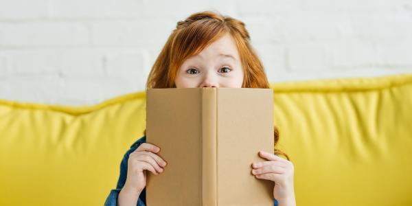a young girl holding a book
