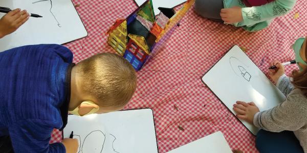 children drawing on a picnic blanket