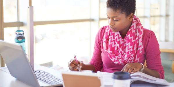 a professional using a computer and taking notes