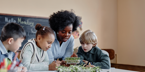 A teacher teaching students about plants in a classroom