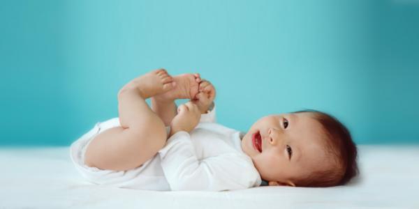 A baby holding his feet in the air