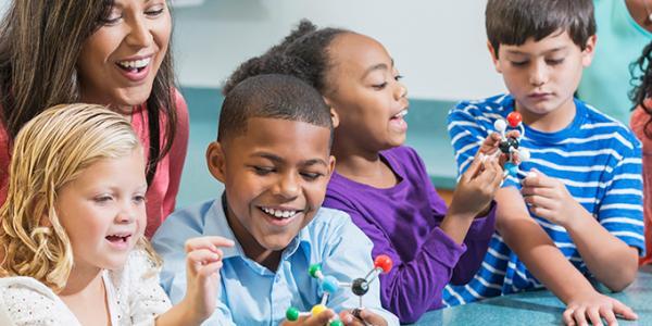 Teacher in a classroom with 4 diverse children