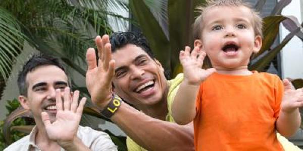 Two fathers playing with son outside 