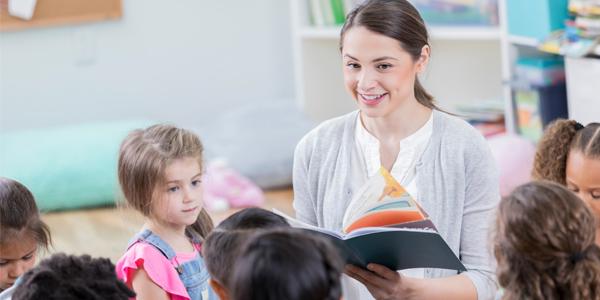 Students listen while the teacher reads a book out loud