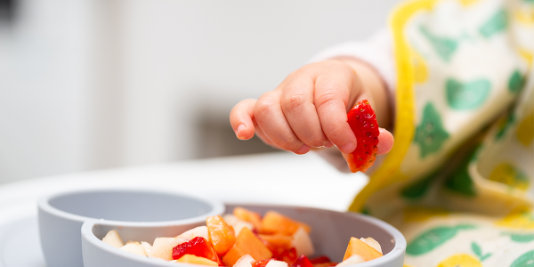 a child picking up some fruit