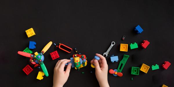 a child's hands playing with assorted toys