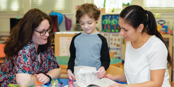 two teachers looking at a childs art project