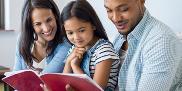 parents reading a book with a child