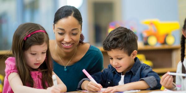 A teacher observing students drawing.