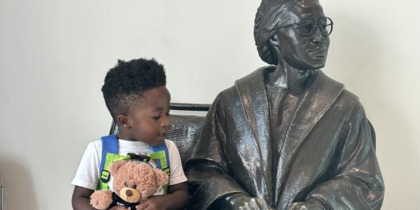 A child sitting with a statue