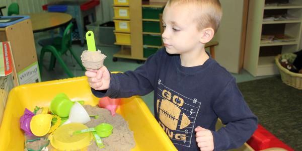 Boy playing in sand table