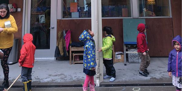 Children standing outside in rain