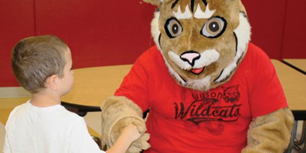 Mascot shaking hands with child