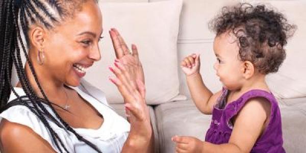 Toddler playing hand game with mother