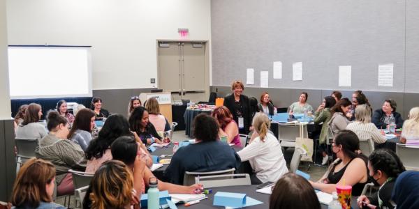 a group of conference attendees in a panel room
