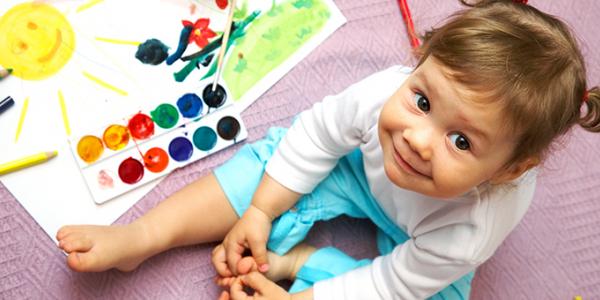Toddler sitting next to a painting kit